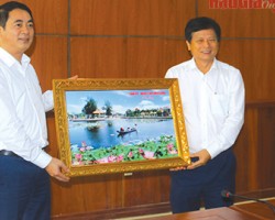 Ông Nghiêm Xuân Thành (bìa trái), Ủy viên Trung ương Đảng, Bí thư Tỉnh ủy, tặng bức tranh về cảnh đẹp tỉnh nhà đến đại diện Hội Nhà báo Thành phố Hồ Chí Minh.