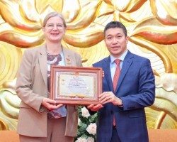 Ông Phan Anh Sơn (phải) trao Kỉ niệm chương “Vì hòa bình, hữu nghị giữa các dân tộc” cho Đại sứ Thụy Điển tại Việt Nam Ann Mawe, ngày 28/6 tại Hà Nội. (Ảnh: Đinh Hòa)