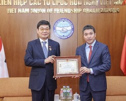 Chủ tịch Liên hiệp các tổ chức hữu nghị Việt Nam Phan Anh Sơn (bên phải) trao kỉ niệm chương cho Chủ tịch Hội đồng Quản trị Công ty CP DK ENC Việt Nam Jang Chin Hyuk, ngày 18/6 tại Hà Nội. (Ảnh: Đinh Hòa)