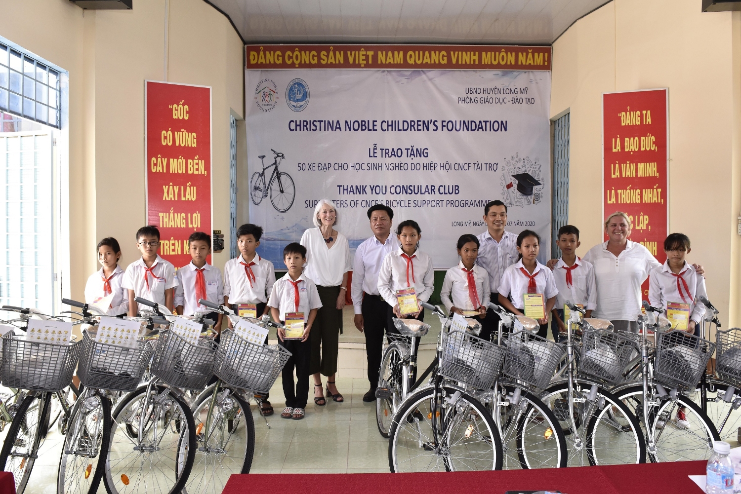 Ông Lê Minh Tuấn - Phó Chủ tịch Liên Hiệp Hậu Giang (thứ 5, từ phải sang) cùng Tổ chức CNCF trao xe đạp cho học sinh nghèo huyện Long Mỹ.