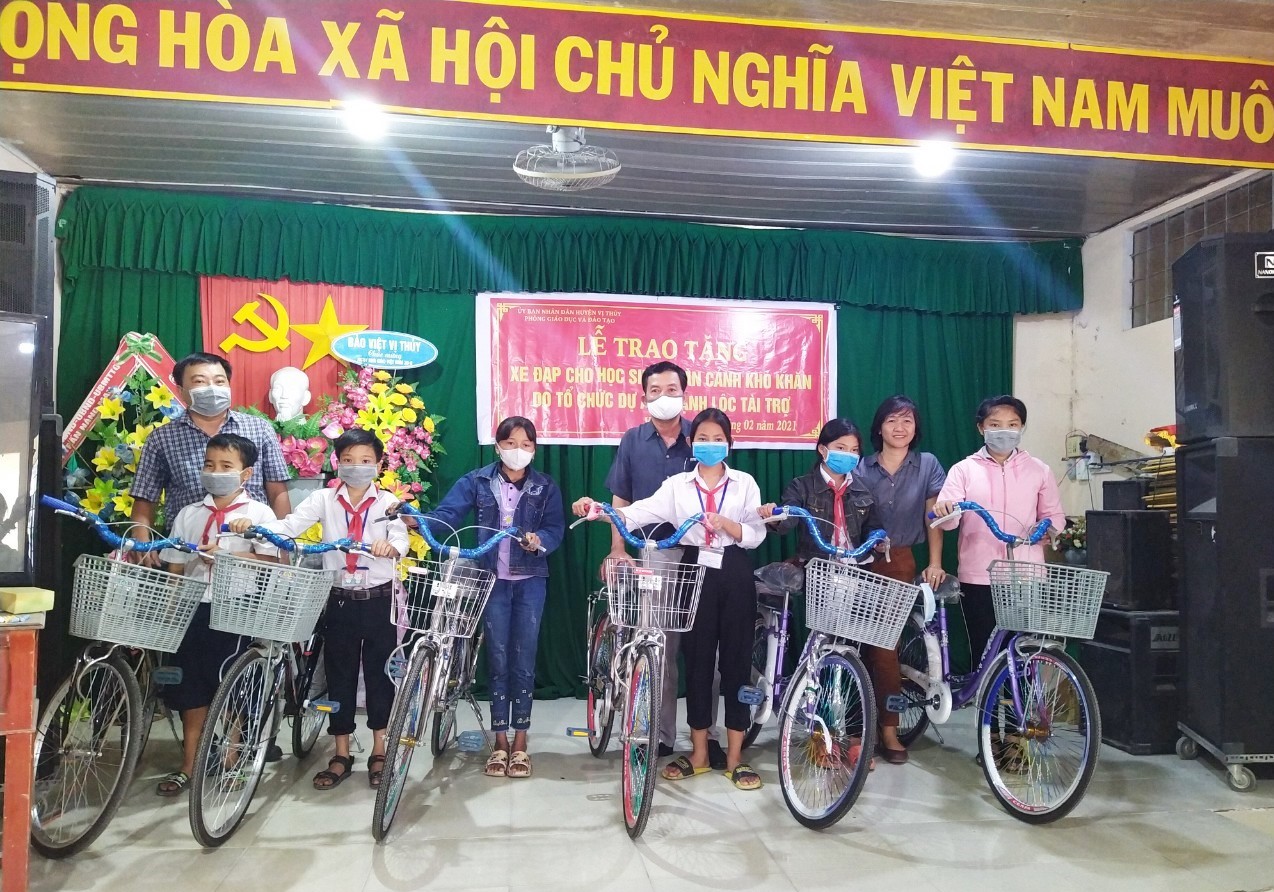 Ông Nguyễn Văn Nhân - Chủ tịch Liên hiệp (sơmi đen) cùng bà Lê Thị Kim Ngân - Đồng sáng lập dự án Thạnh Lộc trao xe đạp cho học sinh nghèo huyện Vị Thủy.