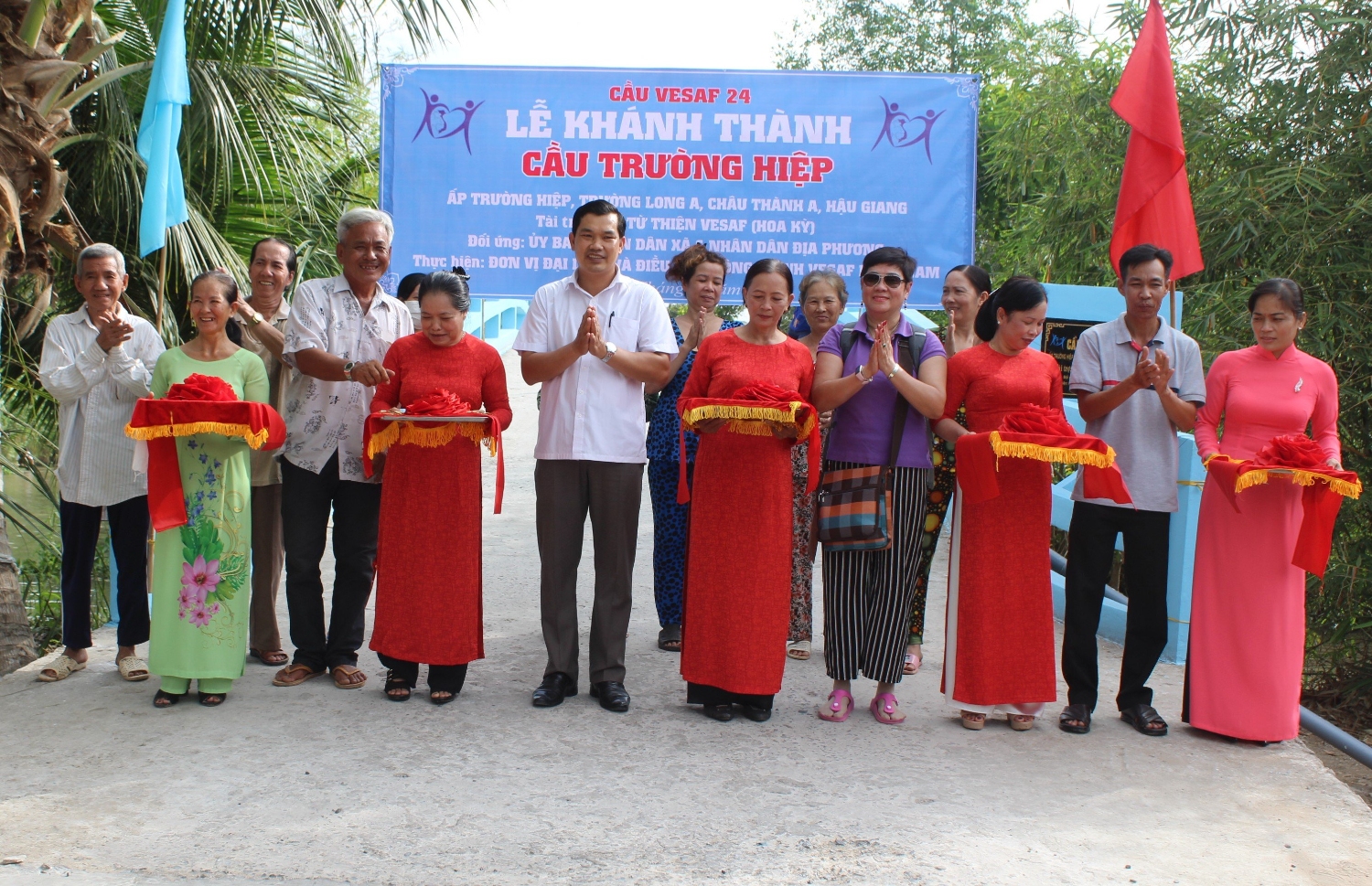 Ông Lê Minh Tuấn, Phó Chủ tịch Thường trực Liên hiệp các Tổ chức hữu nghị tỉnh (thứ 6 từ trái sang) cắt băng khánh thành cầu Trường Hiệp, huyện Châu Thành A, do Qũy từ thiện VESAF (Hoa Kỳ) tài trợ.