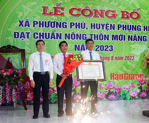 Ông Trần Văn Huyến (bìa trái), Phó Bí thư Thường trực Tỉnh ủy, Chủ tịch HĐND tỉnh, trao bằng công nhận xã đạt chuẩn NTM nâng cao cho lãnh đạo xã Phương Phú.
