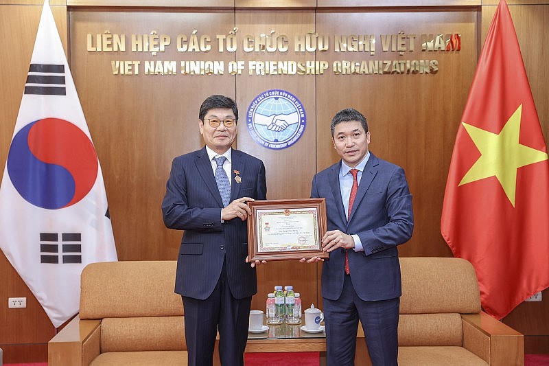 Chủ tịch Liên hiệp các tổ chức hữu nghị Việt Nam Phan Anh Sơn (bên phải) trao kỉ niệm chương cho Chủ tịch Hội đồng Quản trị Công ty CP DK ENC Việt Nam Jang Chin Hyuk, ngày 18/6 tại Hà Nội. (Ảnh: Đinh Hòa)